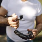 Person hält eine Airbrush mit Spiralschlauch