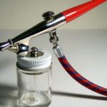 Klassische Airbrush-Pistole mit Farbglas und Luftschlauch