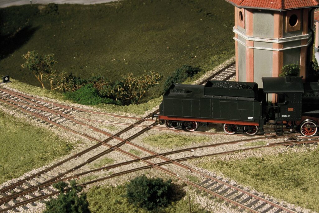 Modell einer Dampflok auf einer Weiche mit begrünter Landschaft
