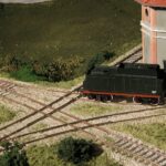 Modellbahnanlage mit Dampflok auf einer Weiche