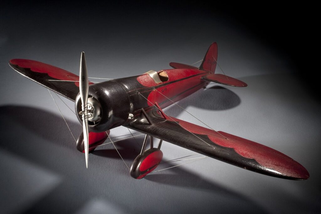 Rotes Flugzeugmodell mit Sternmotor vor dunklem Hintergrund