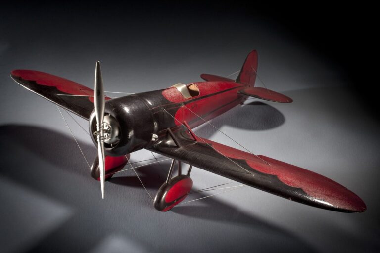 Rotes Flugzeugmodell mit Sternmotor vor dunklem Hintergrund