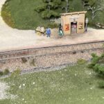 Modell einer kleinen Haltestelle mit Bäumen und Gleis in Spur H0