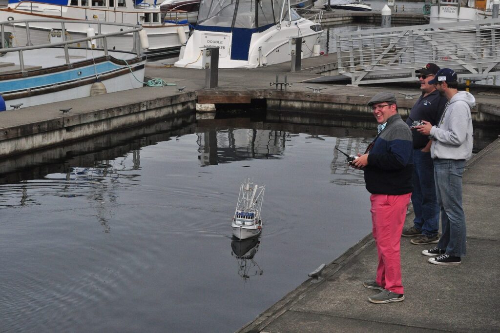 Modellbootfahrer am Hafenbecken mit ferngesteuerten Booten