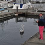Modellbootfahrer am Hafenbecken mit ferngesteuerten Booten