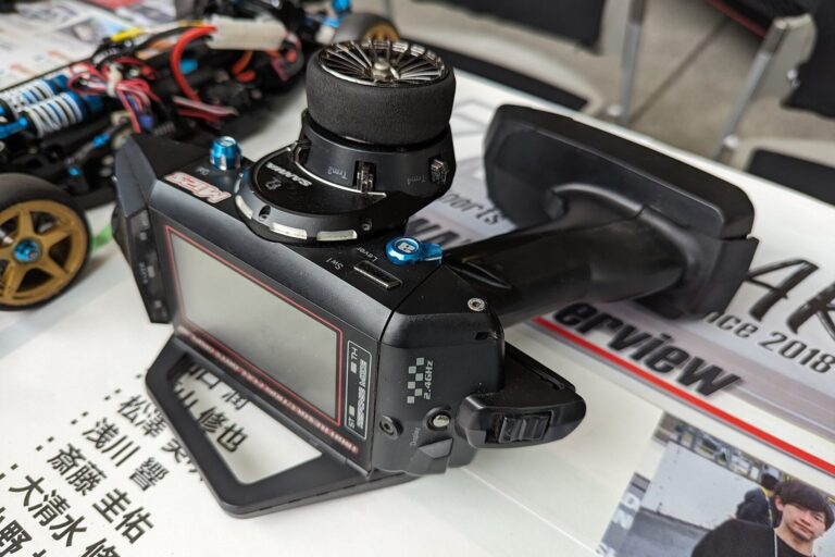Fernsteuerung für ein RC-Modellauto neben einem Chassis
