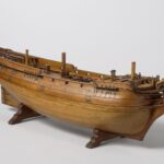 Holzrumpf eines historischen Schiffsmodells auf Ständern